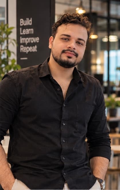 Adnan standing in an office, hands in pockets